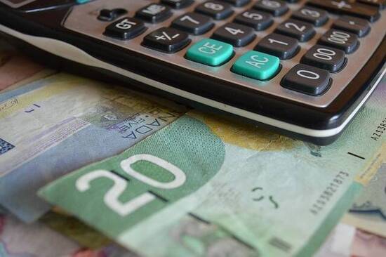 Image of a calculator and money representing the process of financial planning in Winnipeg